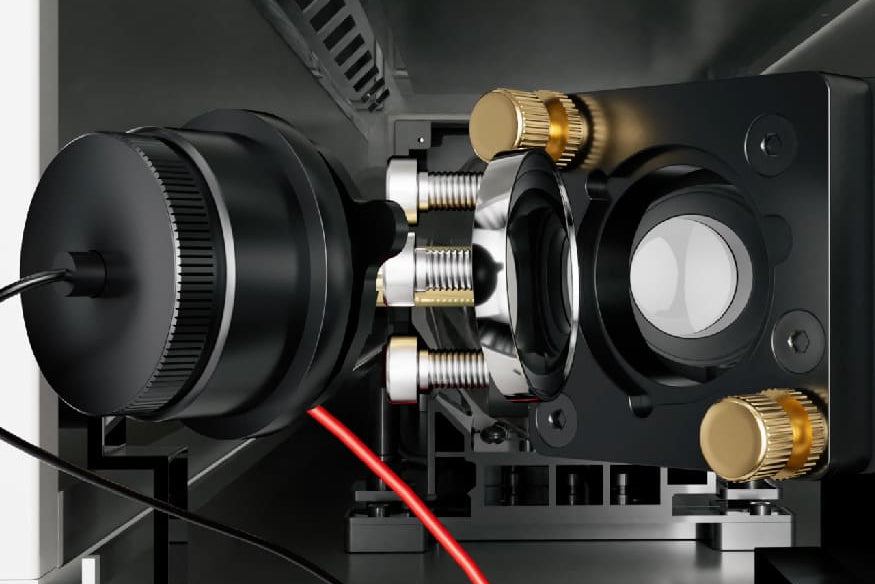 Close-up of a mechanical device with gold and silver components on a dark background